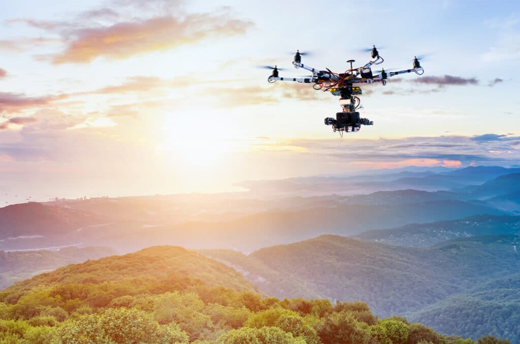 Drohne fliegt über Waldlandschaft im Sonnenuntergang